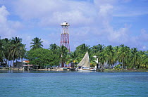 Sailing boat and lighthouse at Sandbore Cay in the northern part of Lighthouse Reef Atoll, Belize