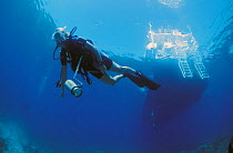 A scuba diver with yacht in the background, Belize Model released.