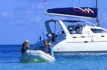 A young family taking the tender of a catarmaran ashore, Belize.