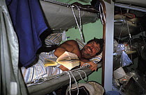Crew member relaxing in his bunk on the Maxi yacht "Drum" during the Whitbread Round the World Race, 1985.