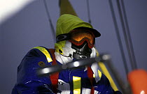 Crew aboard "EF Language" wear full heavy weather clothing, including goggles to protect their eyes during the Whitbread Round the World Race, 1997-98.