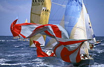 Yachts lower their spinnakers in time for the leeward mark rounding.