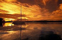 Hallberg Rassy lies at anchor at sunset in the Swedish Archipelago.