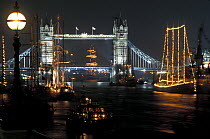 Tall Ships lit up at night near Tower Bridge on the River Thames, London.