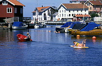 Children play in the harbour of the fishing village at Grundsund on the west coast of Sweden.
