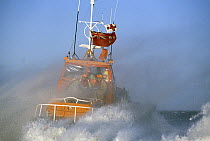 RNLI lifeboat moves out into rough sea off the coast of England.