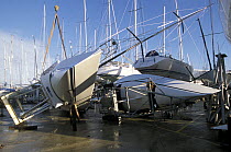 Damaged yachts lie on their sides in the boatyard at Hamble Yacht Services after being blown over in a storm, UK.