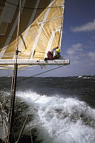 Crew on the boom aboard "The Card" during the Whitbread Round the World Race, 1989-90.