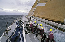 Crew winch in the sails on the coffee grinders following a sail change on the "The Card" during the Whitbread Round the World Race, 1989-90.