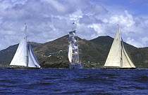 J-Class "Shamrock V" (left) and "Velsheda" race past the Tall Ship "Star Clipper" at Antigua Classics, 1999.