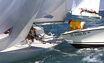 Melges 24 has caught the guard rail over a rescue boat at Key West Race Week, 2000.