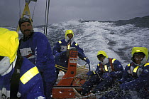 Crew on "EF Language" wear full heavy weather clothing while racing during the Whitbread Round the World Race, 1997-1998.