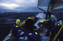 Crew "EF Language" wear full heavy weather clothing while racing during the Whitbread Round the World Race, 1997-98.