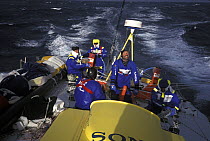 Crew on "EF Language" wear full heavy weather clothing while racing during the Whitbread Round the World Race, 1997-98.