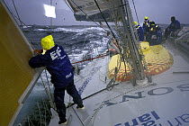 Water rushes past the crew on deck of "EF Language" during the Whitbread Round the World Race, 1997-1998.