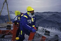 Crew on "EF Language" wear full heavy weather clothing including googles to prevent the salt water spraying into their eyes during the Whitbread Round the World Race, 1997-98.