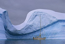Skip Novak's yacht "Pelagic" by a massive weathered iceberg in Fournier Bay, Antarctic Peninsula.