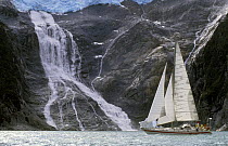 Skip Novak's yacht "Pelagic" passes beneath a glacial waterfall in southern Chile, South America.