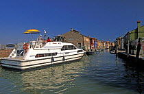 Houseboat entering Burano, an archipelago of islands in the Venetian lagoon, Venice Province, Italy.