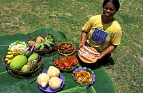 Woman with traditional local food: cooked crabs, fish, different types of bananas, pineaple, papaya, tapioca, soursop, taro, sweet potatoes etc. Palau.