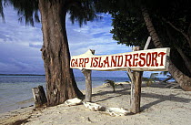 Carp island resort sign with tridacna shells underneath, Carp island, Palau.