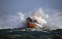 Alderney, Channel Islands Lifeboat covered in spray as it crashes through heavy seas.