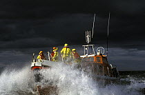 Crew of the Courtmacsherry, Ireland Lifeboat on the foredeck as she crashes through heavy seas. Designed to lie afloat at deep water moorings or at berth. The sheerline sweeps down for ease of survivo...