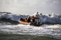 Hayling Island, Hampshire inshore lifeboat heads into the surf. Based on the Atlantic 21. ^^^Even though her twin 70hp outboard engines make her one of the fastest lifeboats in the fleet, her hull des...