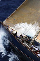Foredeck crew stowing the gennaker away, as a bow wave catches inside the jib aboard J-Class "Velsheda" as she beats upwind at Antigua Classics 2003.