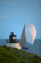 Racing yacht at the finish line of the Annapolis to Newport race at Castle Hill Lighthouse, Newport, Rhode Island, USA.