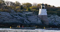 Trap fishing boats being towed out to sea past Castle Hill Lighthouse in the early morning destined for fishing grounds off Newport, Rhode Island, USA.