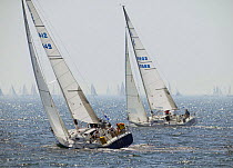 Two J-105's heading upwind while a fleet glides by on the horizon, Block Island Race Week, Rhode Island, USA, 2003.