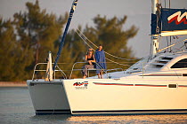Mother and daughter on bow of a 38ft catamaran anchored in the Abacos Islands, Bahamas. Model released.