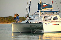 Mother and daughter on bow of a 38ft catamaran anchored in the Abacos Islands, Bahamas. Model released.