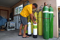 Staff member filling a nitrox tank at a nitrox blending fill station, Hawaii.