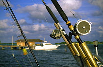 Fishing rods with boat behind, Little Cayman, Cayman Islands.