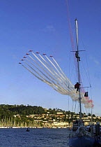 Red Arrows display during the Dartmouth Regatta, with men up a mast. Devon, England, UK.