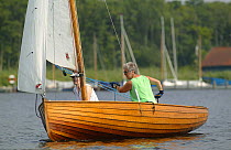 Trimming the sail on a classic wooden gaffer, Wroxham Open Regatta Week, Wroxham Broads, Norfolk, England, UK.
