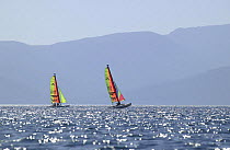 Two hobie cats sailing on the calm waters off the coast of Turkey.