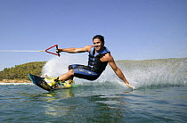 A wakeboarder leaning in and touching the water, Marverde, Turkey. Model Released.