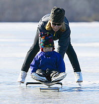 Mother and child ice skating on Worden Pond, Rhode Island, USA. Model released.