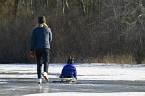 Mother and child ice skating on Worden Pond, Rhode Island, USA.