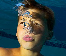 Boy blowing bubbles underwater. Model released.
