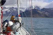 Crew aboard the 88ft Sloop yacht "Shaman", watching ahead as they motor into Cumberland Bay, South Georgia.