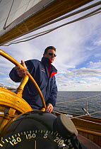The skipper of "White Hawk" keeping a good compass course while sailing off Newport, Rhode Island, USA.