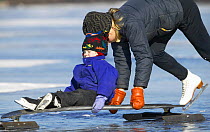 Mother and child ice skating and sledging on Worden Pond, Rhode Island, USA.