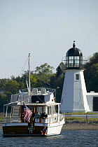 Grand Banks motoryacht moored off a small lighthouse on the east coast, USA.