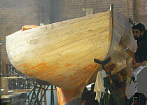 Fairing the hull of a restored boat at the International Yacht Restoration School (IYRS0) in Newport, Rhode Island, USA.