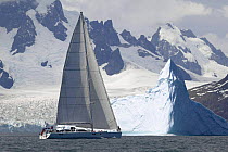 The 88ft sloop ^Shaman^ sailing under a backdrop of snow covered mountains and glaciers off the south coast of South Georgia. Property Released.