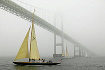 12 meters "Northern Light" and "Gleam" gliding under the Newport Bridge in fog, Rhode island, USA. Both boats are property released.